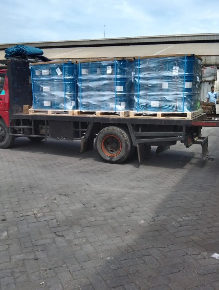 Truk dengan Drum Biru di Pallet